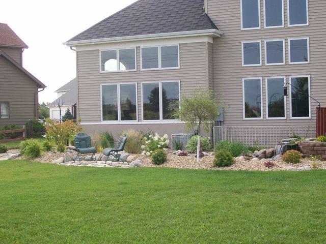 A house with a lot of windows and a lush green lawn
