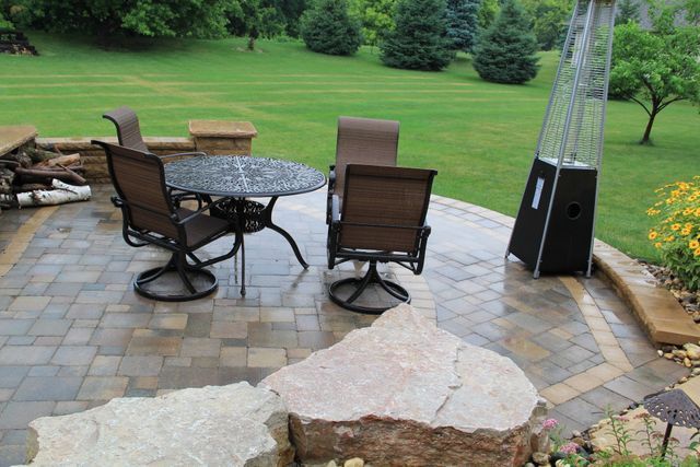 A patio with a table and chairs and a heater.