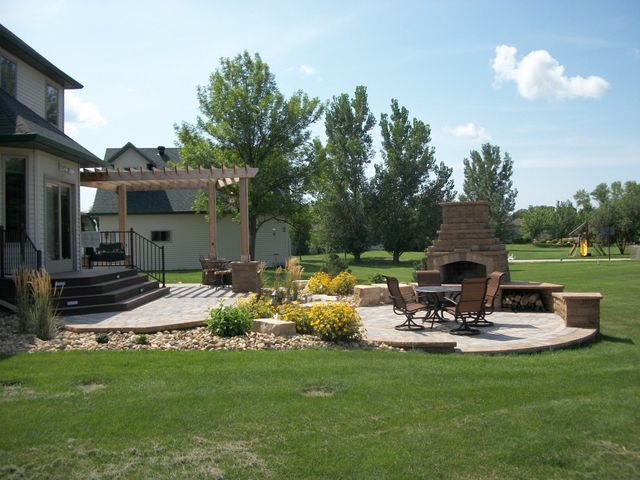 A house with a patio and a fireplace in the backyard