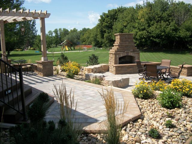 A patio with a fireplace and a table and chairs