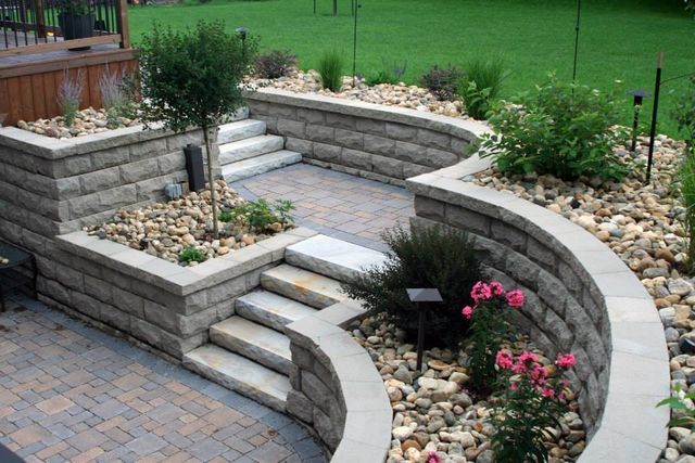 A brick wall with stairs leading up to it in a garden.