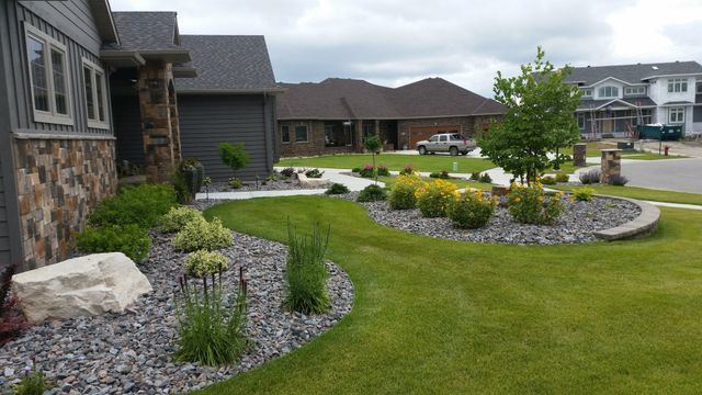 A house with a lush green lawn in front of it.
