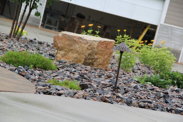 A large rock is in the middle of a rock garden