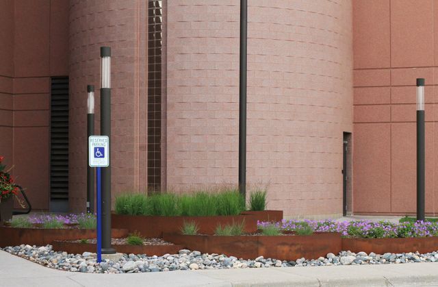 A handicapped parking sign is in front of a building.