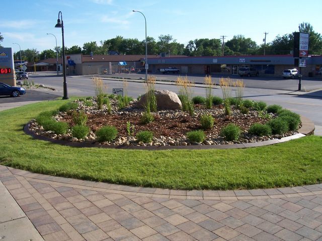 A round garden with a large rock in the middle of it