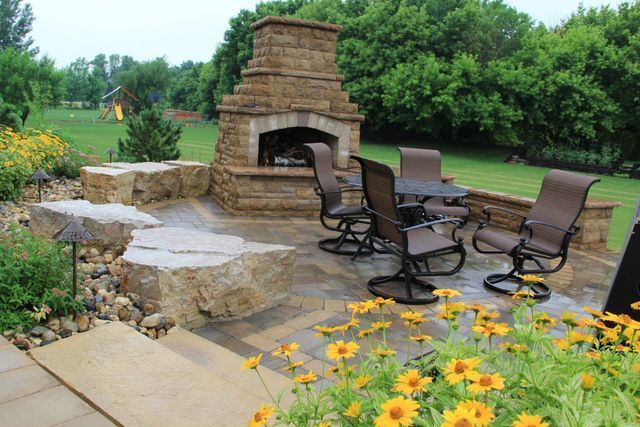 A patio with a fireplace and tables and chairs