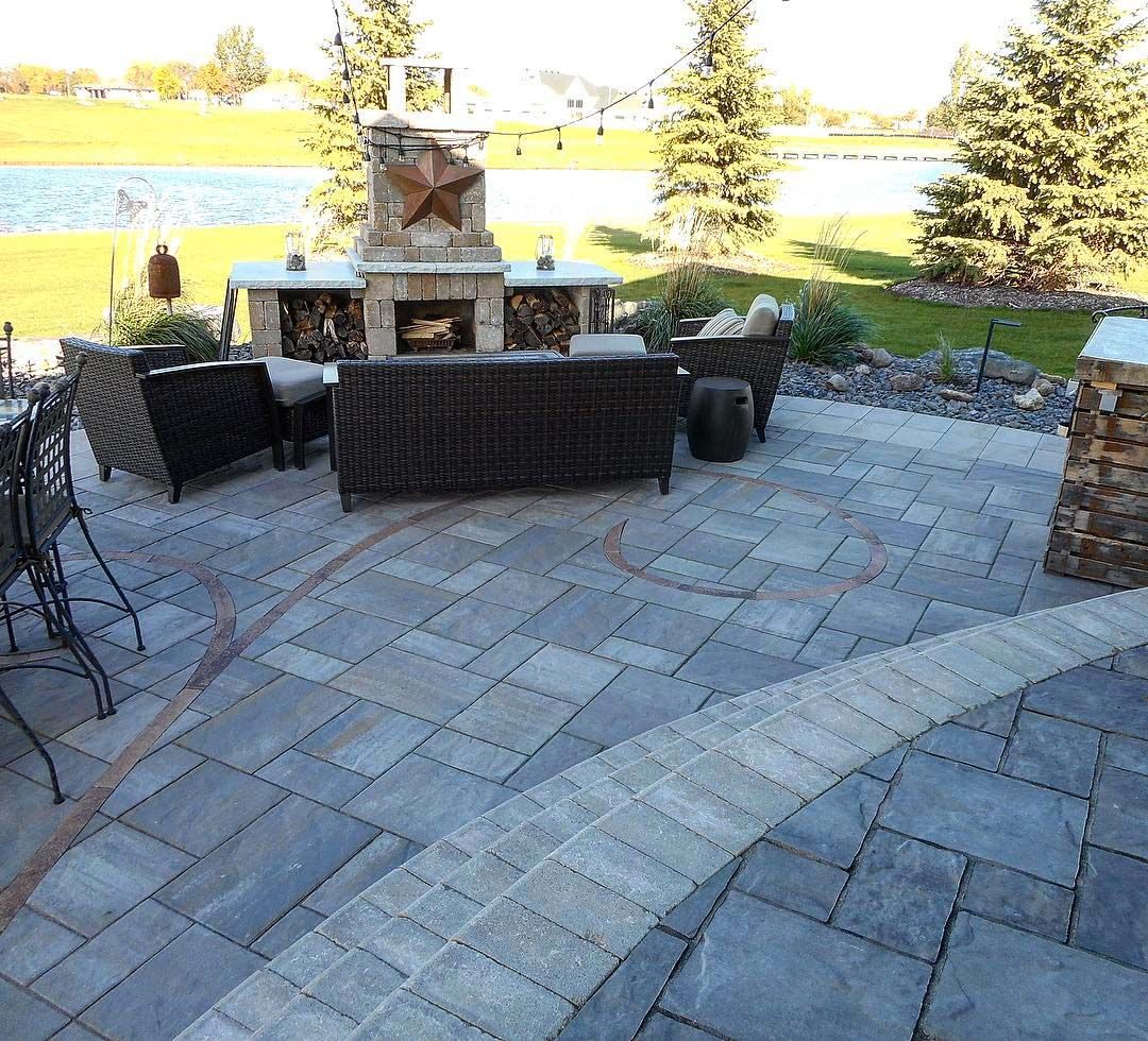 A patio with a fireplace and a couch and chairs