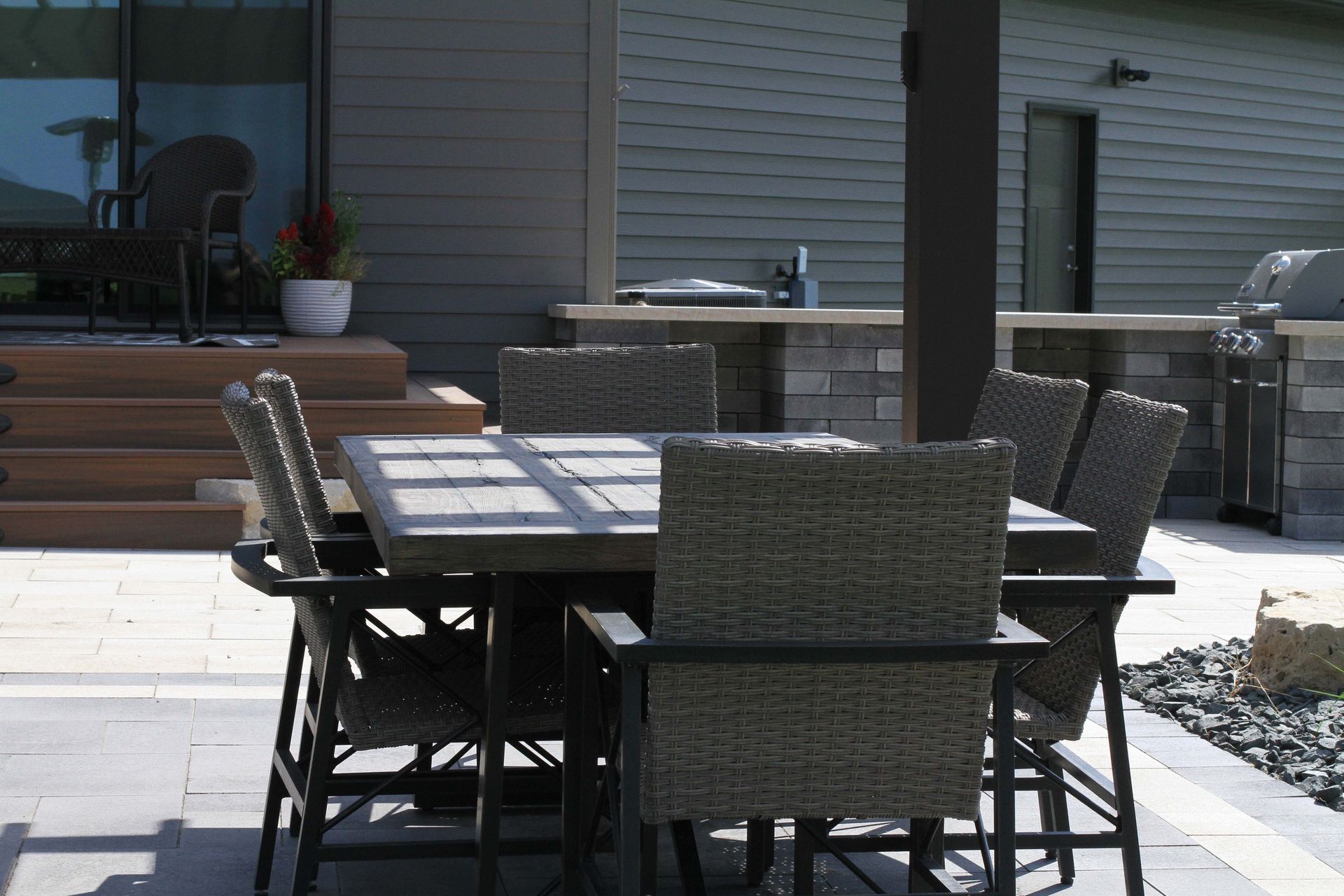 A patio with a table and chairs in front of a house.
