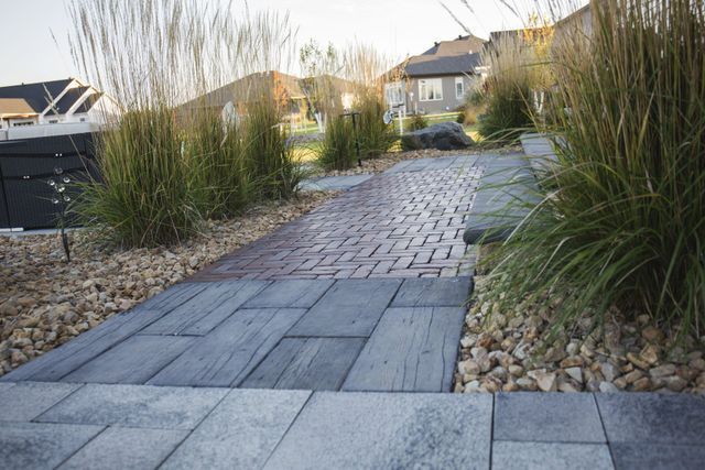 A brick walkway leading to a hot tub in a backyard.