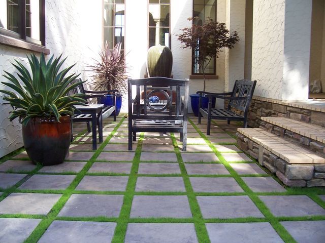 A patio with chairs and potted plants on it