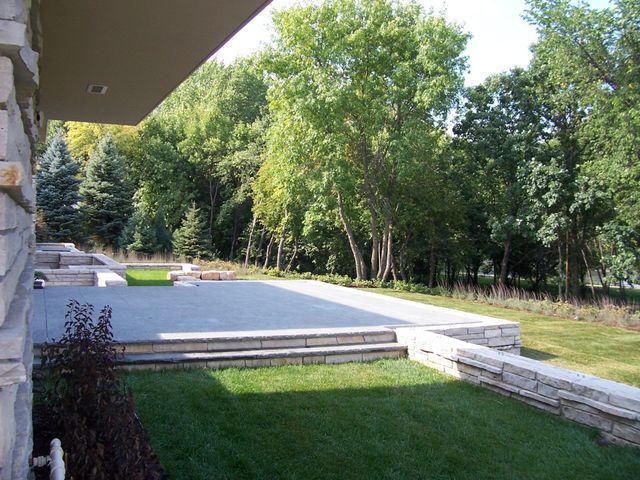 A lush green lawn with trees in the background