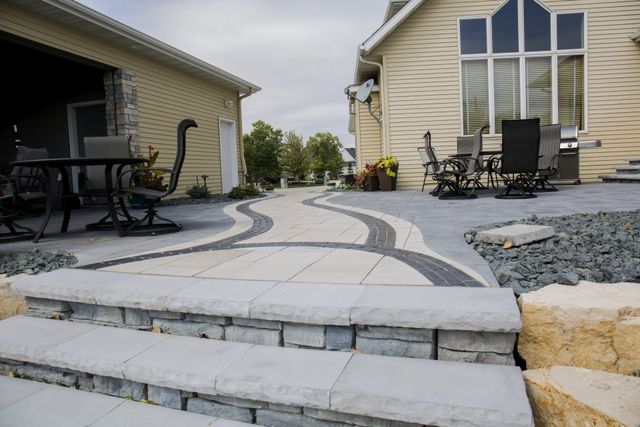 A patio with a table and chairs in front of a house