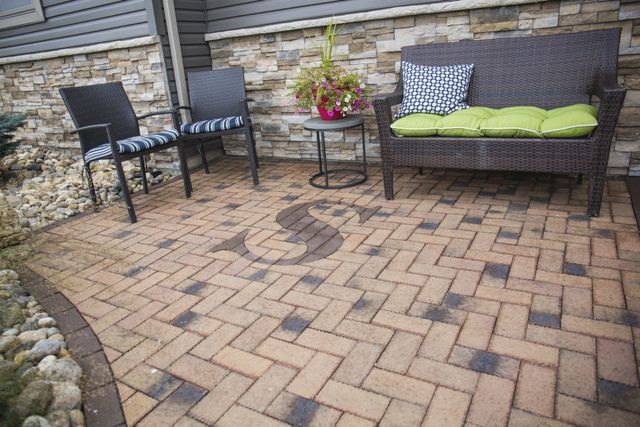 A patio with a couch , chairs and a table.