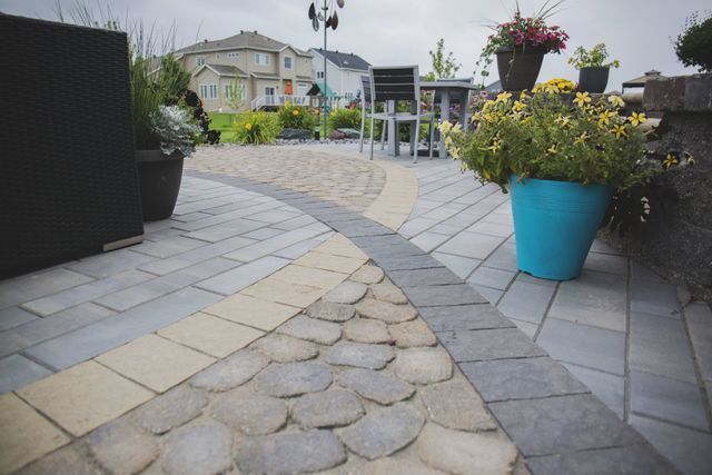 A patio with a blue pot of flowers in the middle of it.