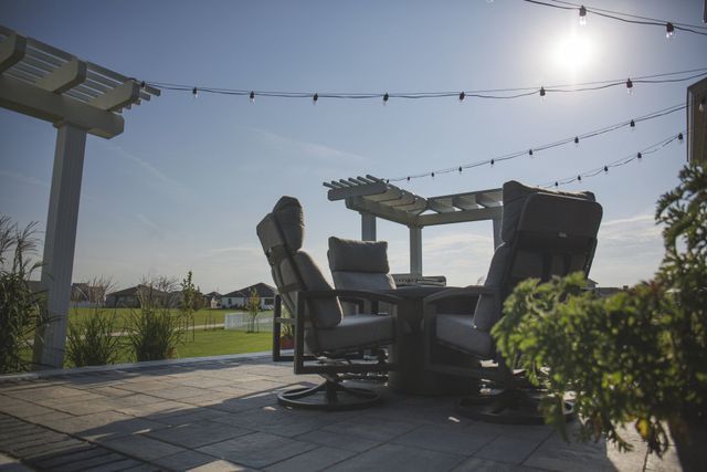 A patio with a table and chairs under a pergola.
