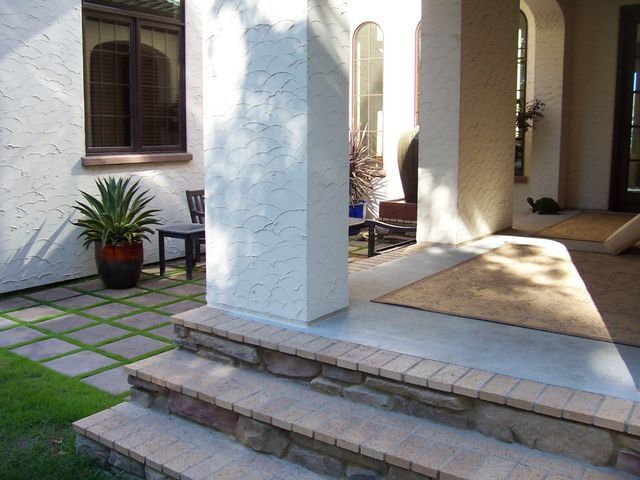 A white house with a porch and steps leading up to it