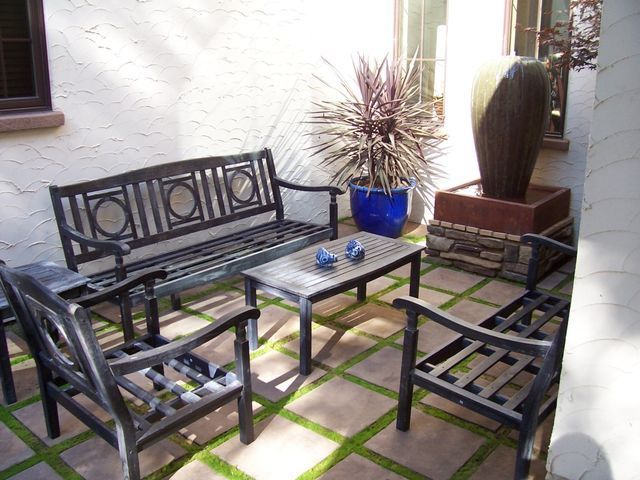 A patio with a bench and chairs and a table