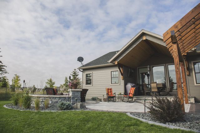 A house with a patio and a pergola in front of it.