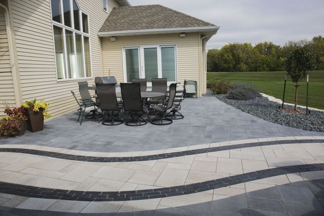 A patio with a table and chairs in front of a house.
