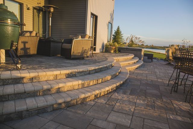 A patio with stairs leading up to a house and a green egg.