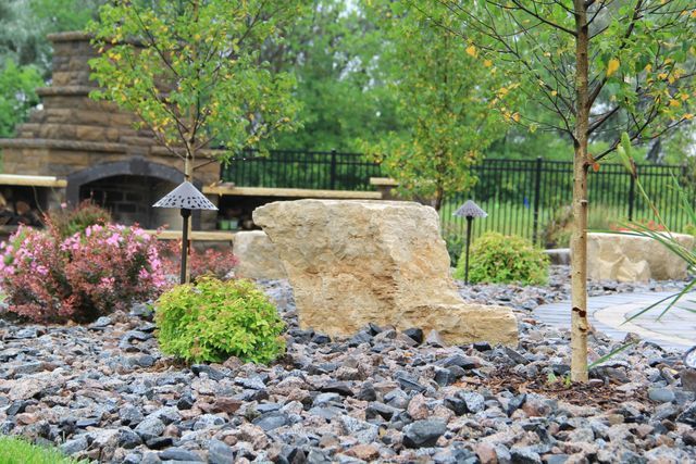 There is a large rock in the middle of the garden.