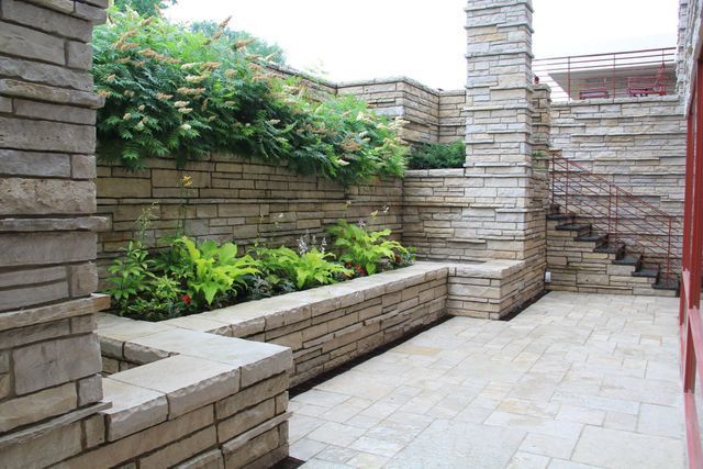 A brick wall with a planter in the middle of it.