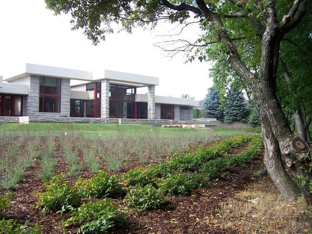 A large house is surrounded by trees and bushes