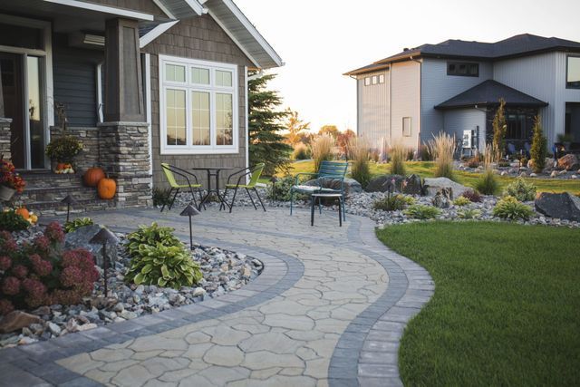 A house with a patio and a table and chairs in front of it.
