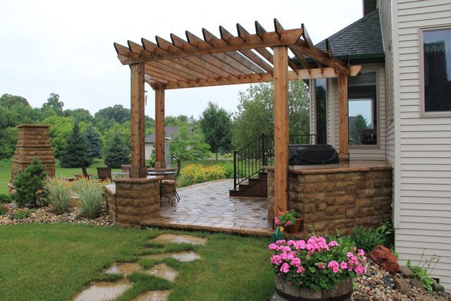 There is a pergola in the backyard of a house.