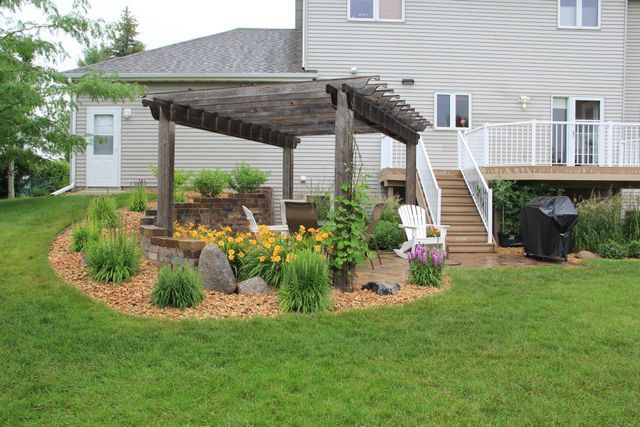 A house with a pergola and stairs in the backyard