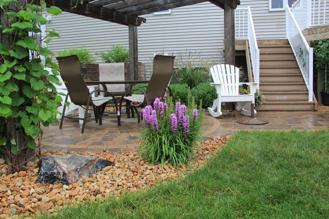 A patio with a table and chairs under a pergola.