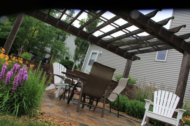 A pergola with a table and chairs underneath it