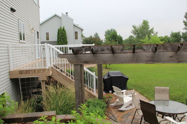 A patio with a table and chairs under a pergola.