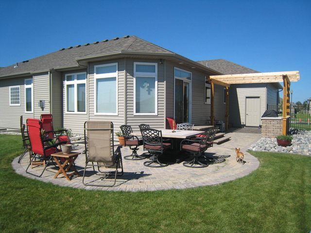 A patio with a table and chairs in front of a house