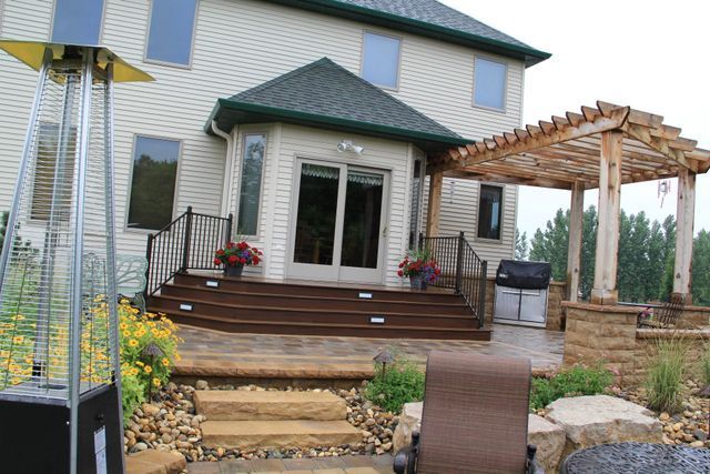 A large house with a patio and a pergola in front of it.