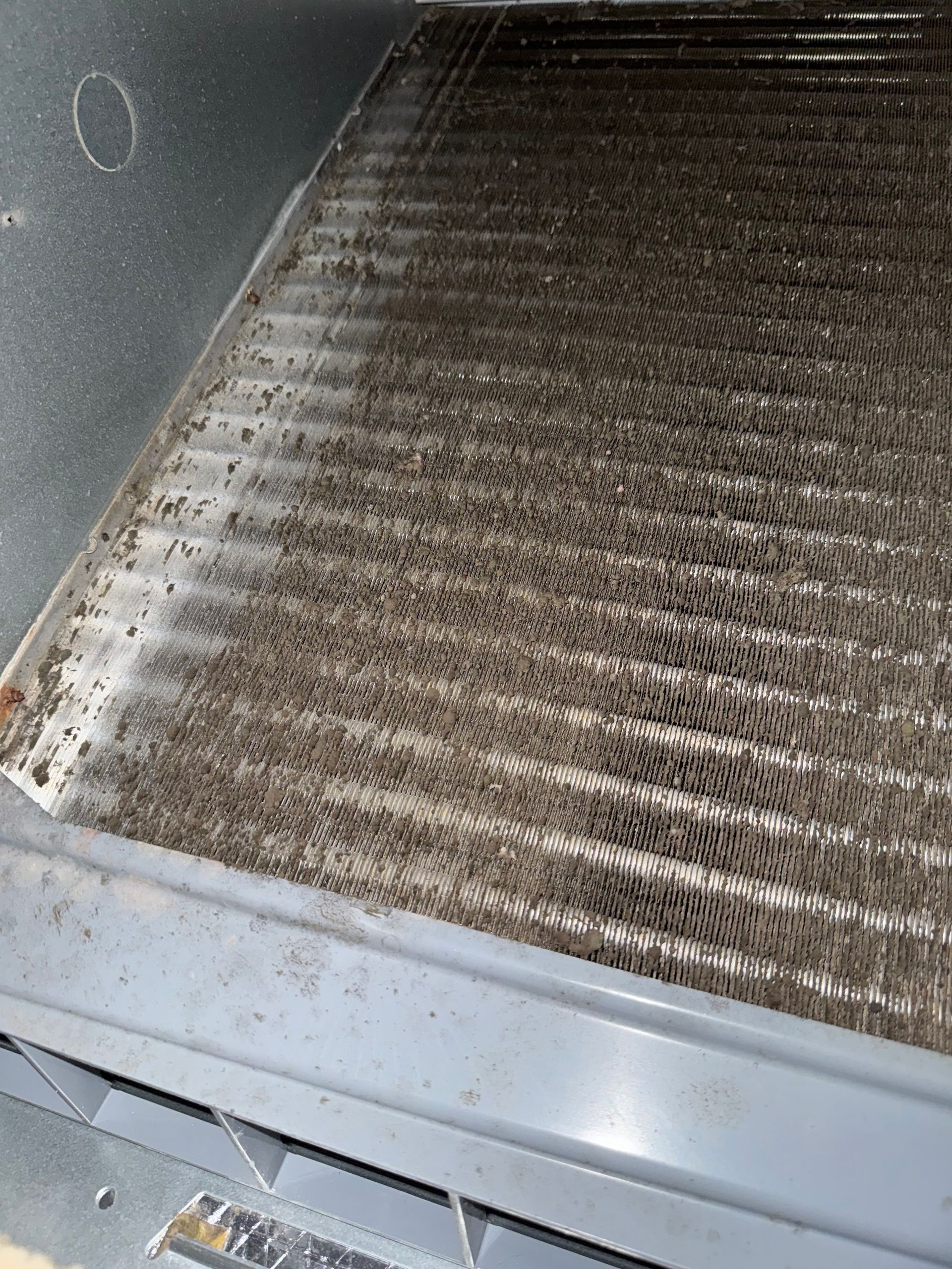 Dirty HVAC air filter covered in dust and debris inside a metal unit