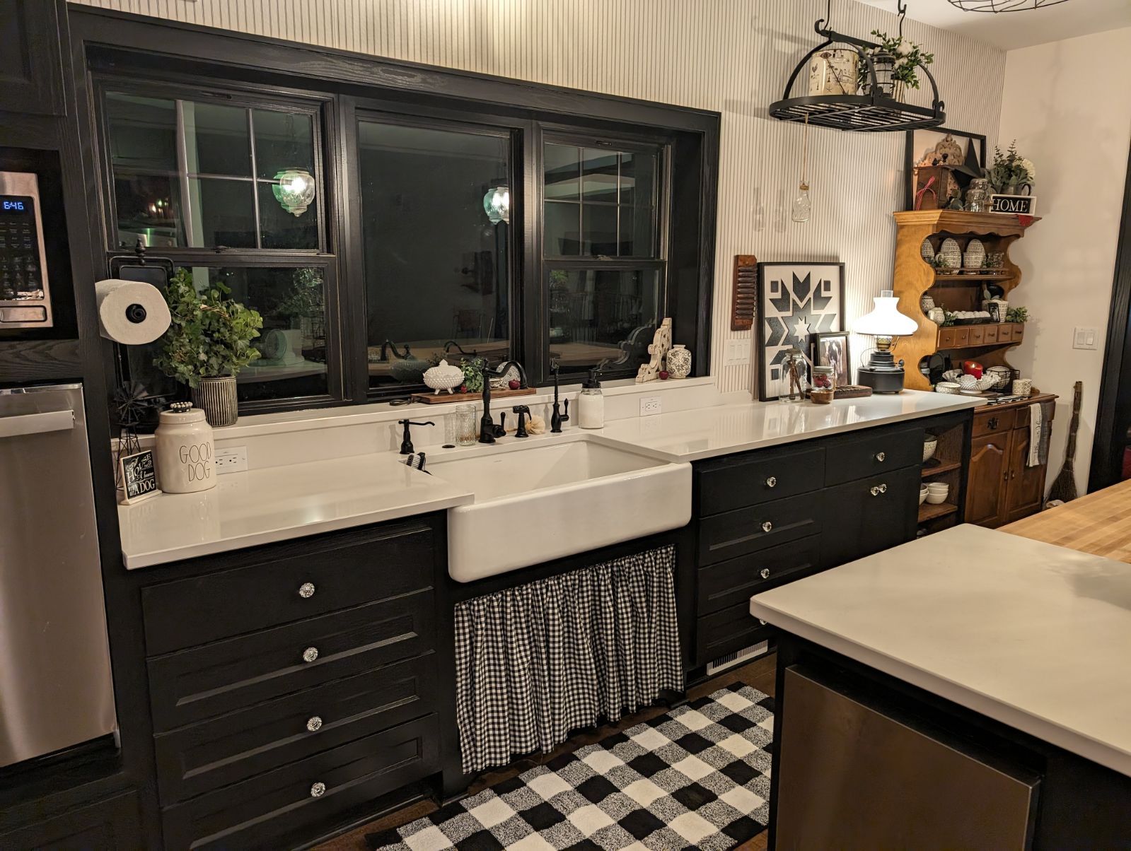 A kitchen with black cabinets and a white sink