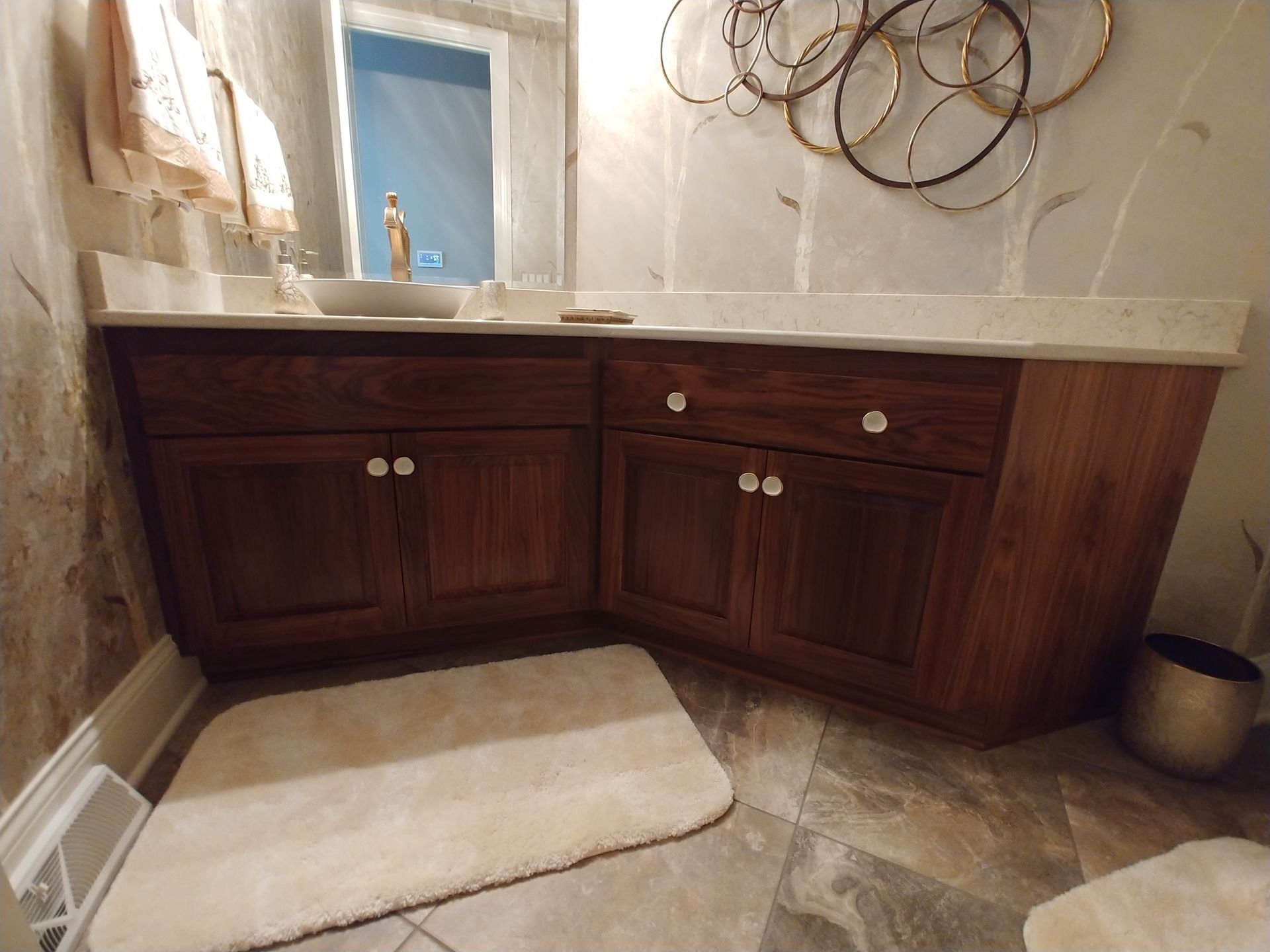 A bathroom with a sink, cabinets, and a rug