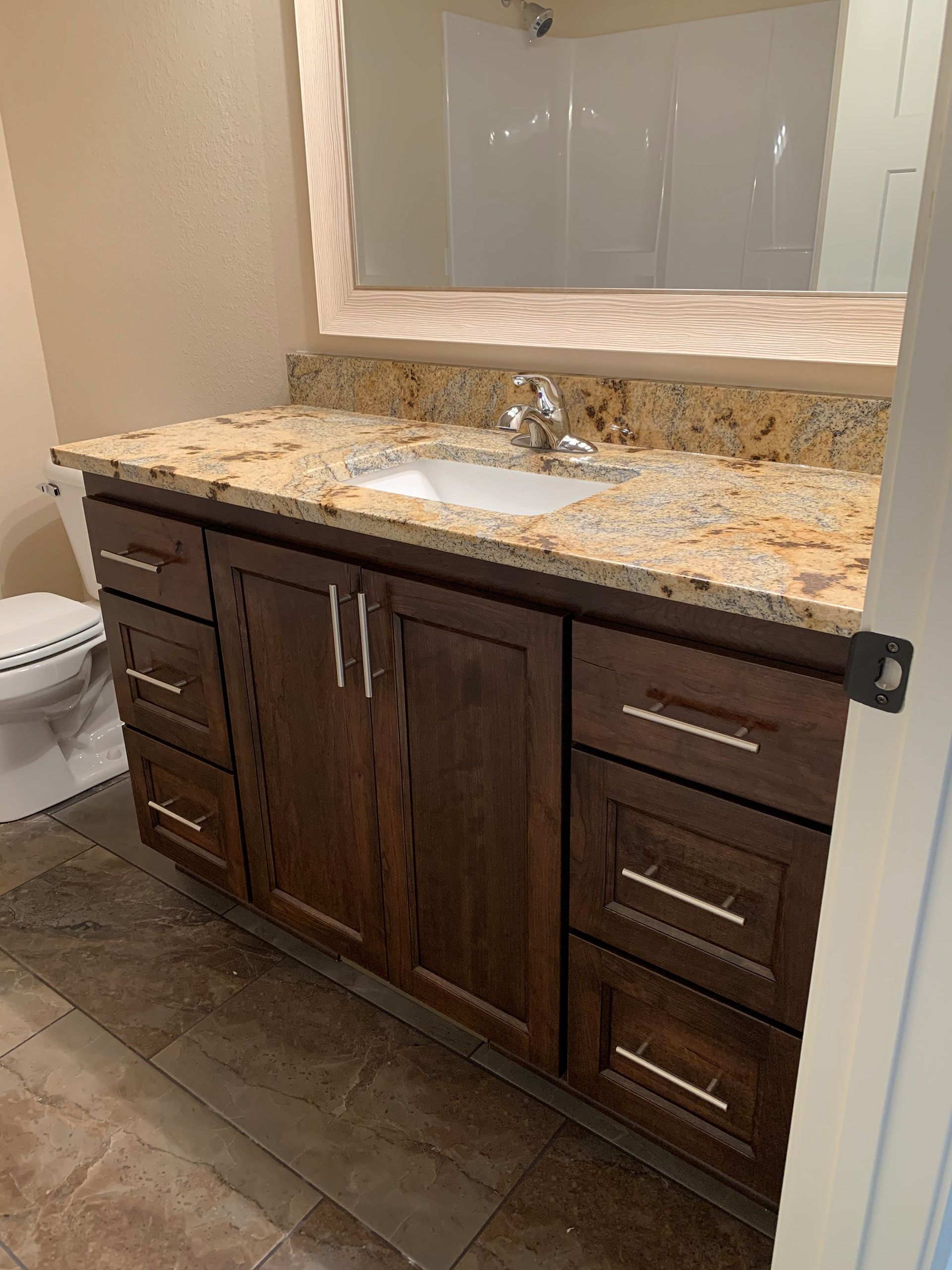 A bathroom with a sink, toilet, and mirror