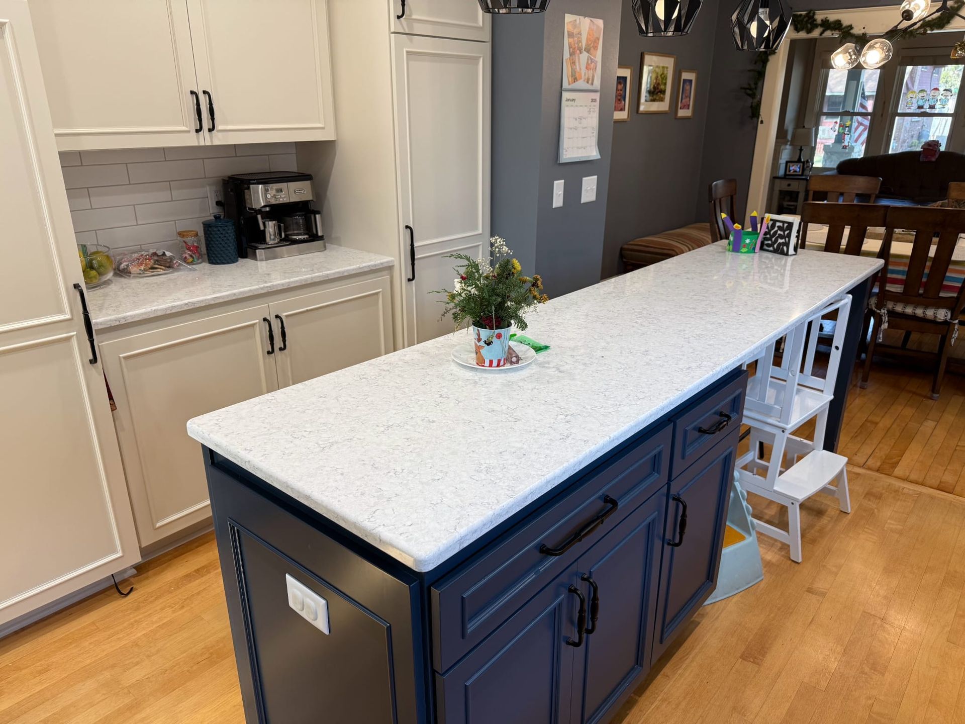 A kitchen with a large island and white counter tops.