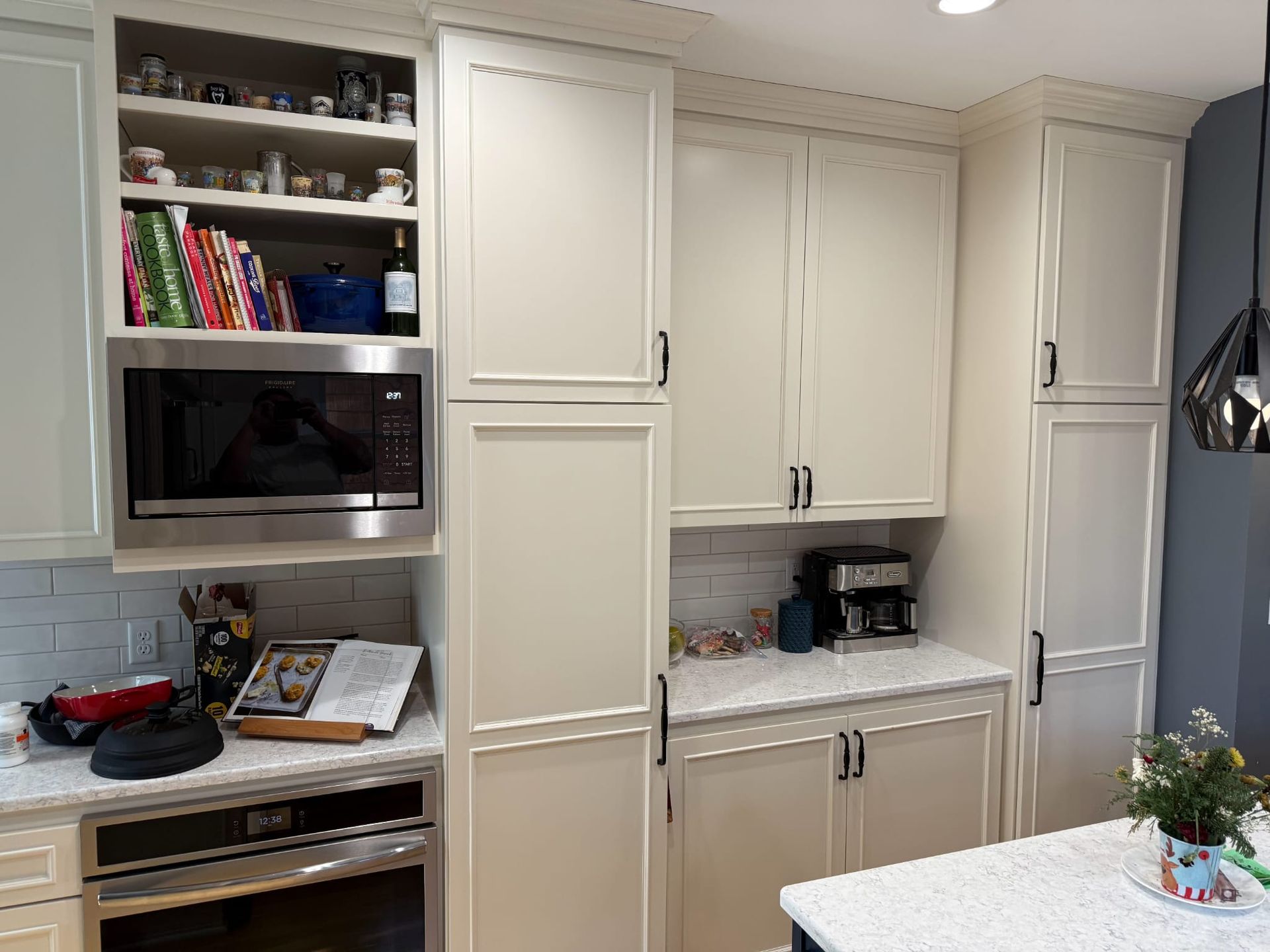 A kitchen with white cabinets , stainless steel appliances and a microwave.