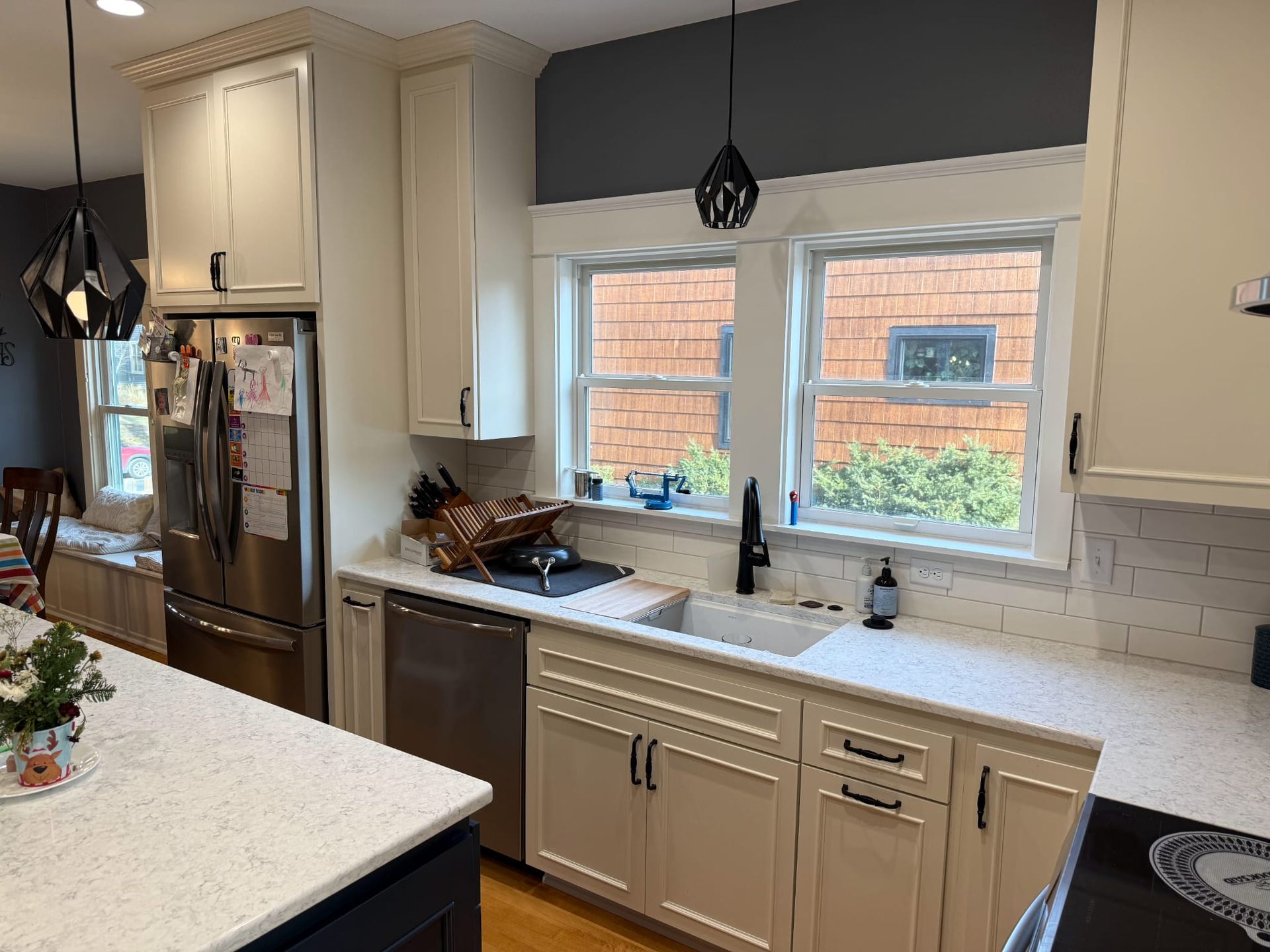 A kitchen with white cabinets , stainless steel appliances , a sink , and a refrigerator.