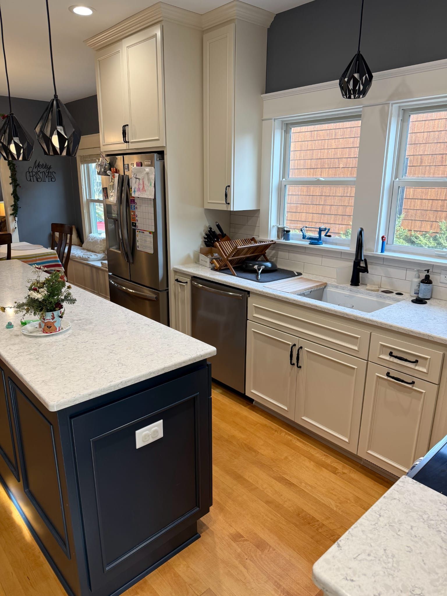A kitchen with white cabinets , stainless steel appliances , and a large island.