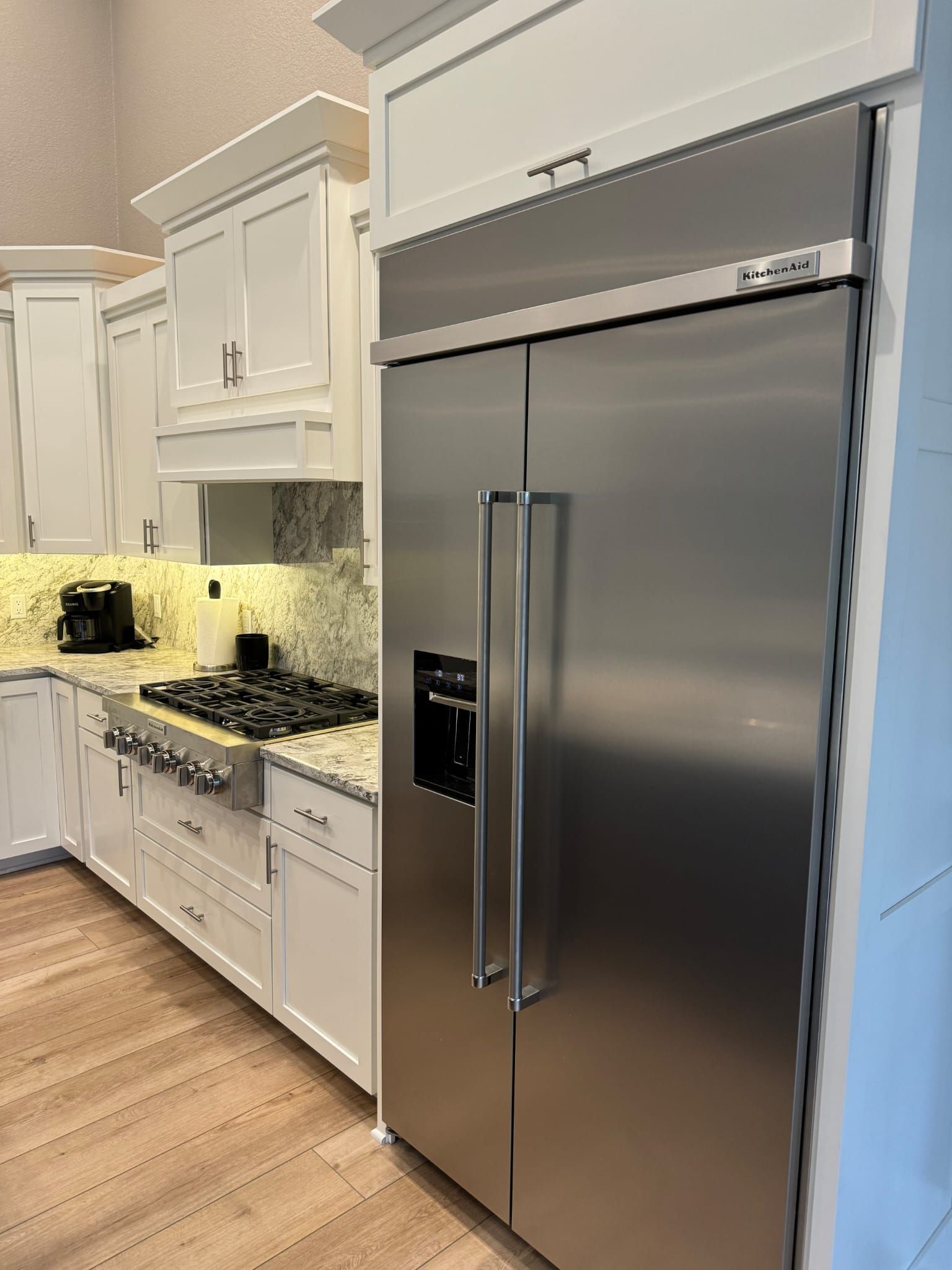 A kitchen with stainless steel appliances and white cabinets.