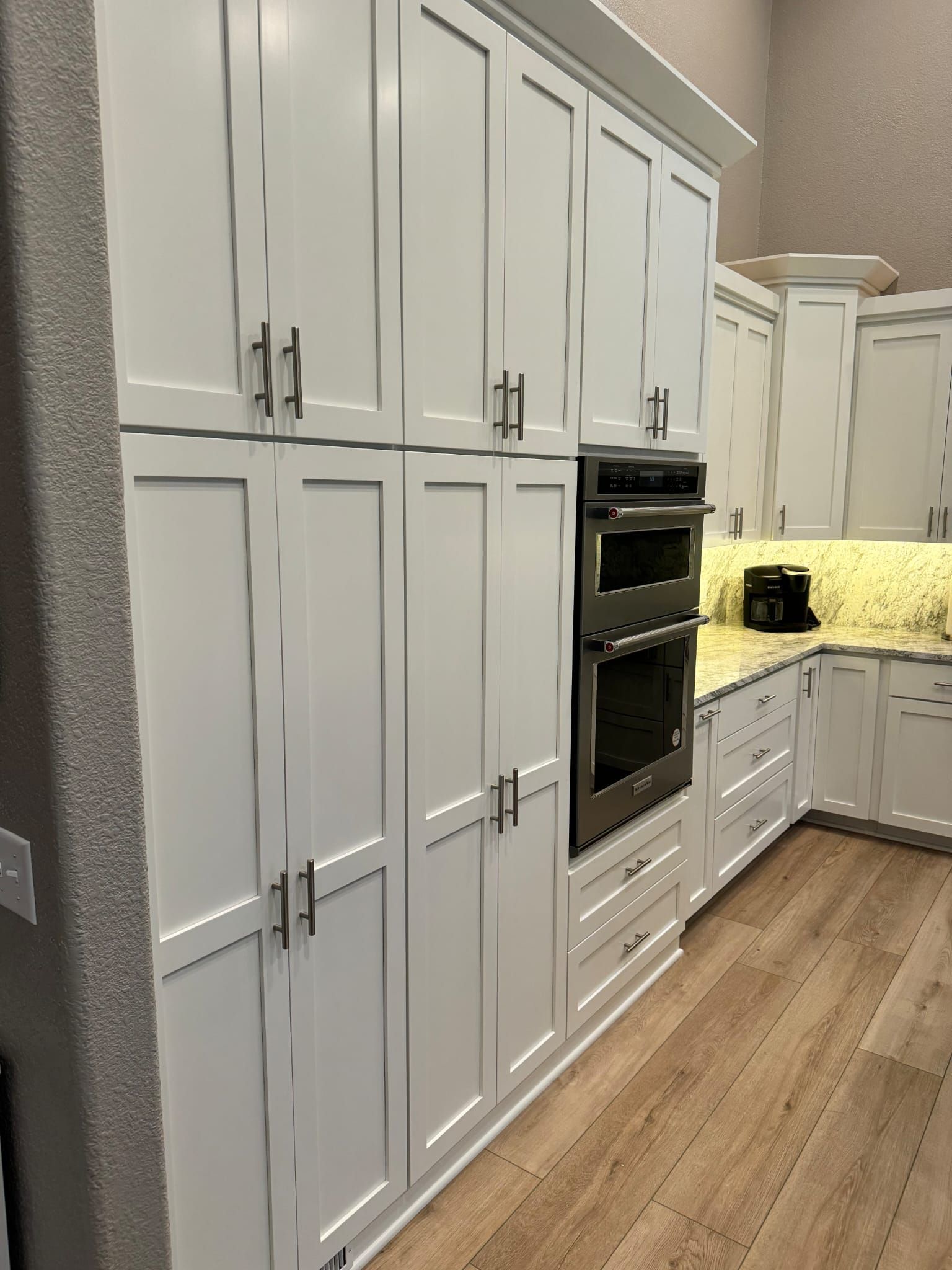 A kitchen with white cabinets and stainless steel appliances.