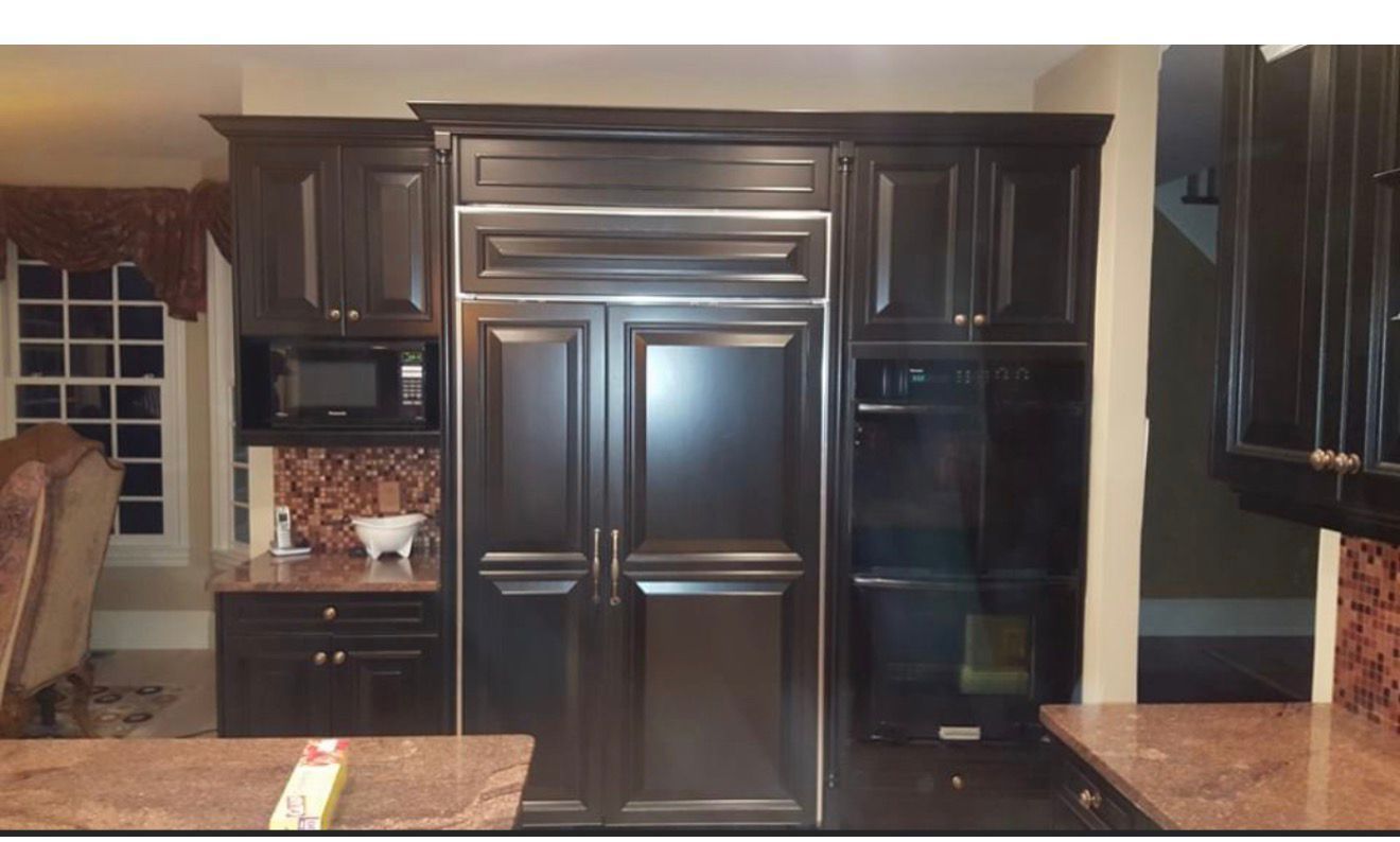 Dark wood kitchen cabinets with built-in stainless steel appliances and granite countertops