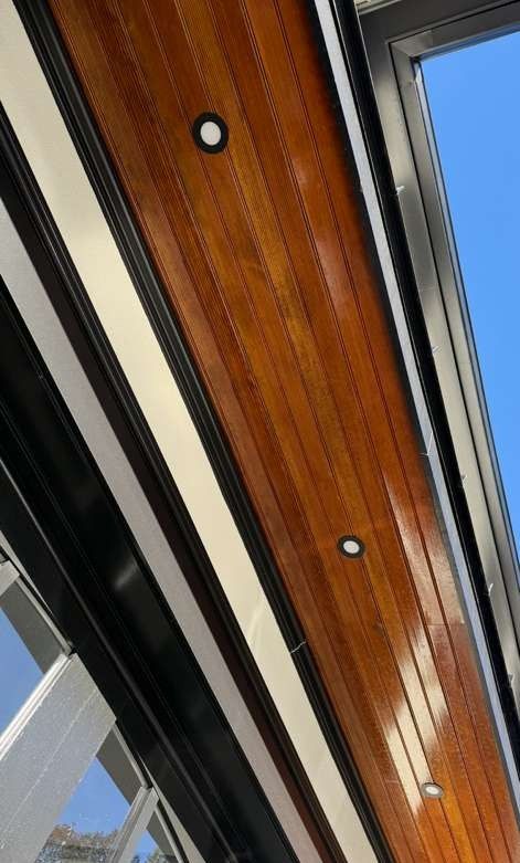 Wood-paneled ceiling with recessed lights and skylight windows in a modern interior