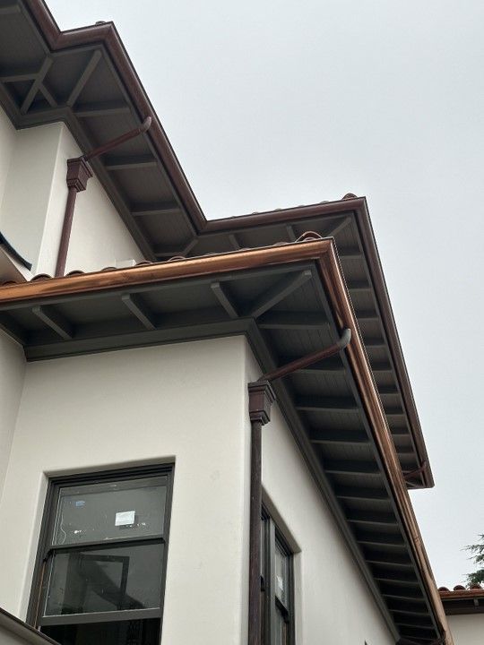 A house with a gutter on the side of it.