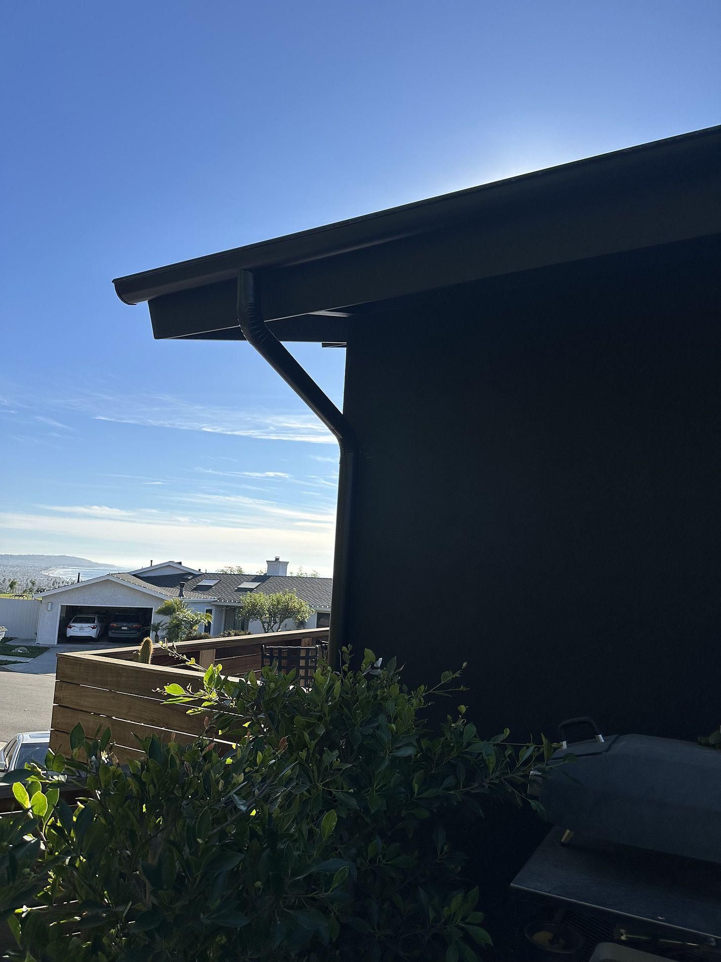 A black building with a blue sky in the background.