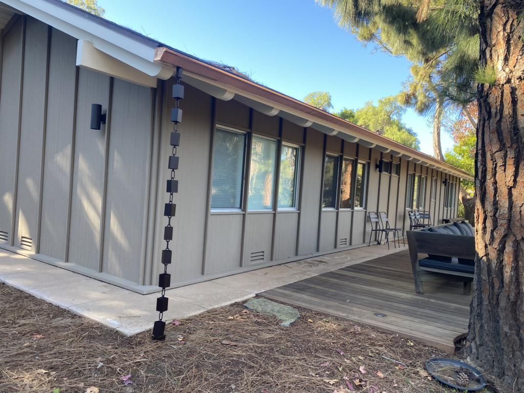 A house with a rain chain attached to the side of it.